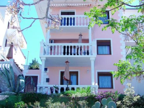 a pink building with a balcony in front of it at Apartmens Špiko 2 in Hvar