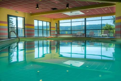 a swimming pool with water in a building at Evasion Tonique in Villers-le-Lac