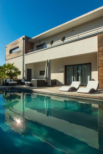 une maison avec une piscine devant une maison dans l'établissement La Villa du Triangle, au Cap d'Agde