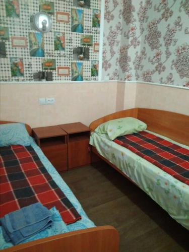 a bedroom with two beds and a nightstand and a bed sidx sidx sidx sidx at Hostel Mnogoborets F. Klub in Odesa