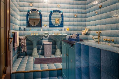 Baño azul con 2 lavabos y espejo en Dimora del Bonsignore en Turín