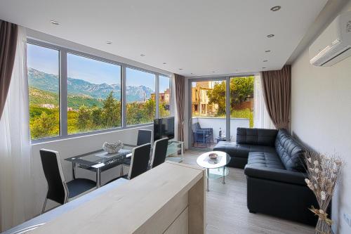 a living room with a couch and a large window at Montelux Apartments in Budva