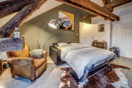 a bedroom with a bed and a chair at Gite "le millésime" in Épernay