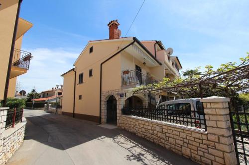 una casa con una pared de ladrillo y una valla en Apartments Milka, en Rovinj