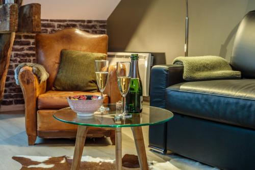a living room with a couch and a table with glasses at Gite "le millésime" in Épernay