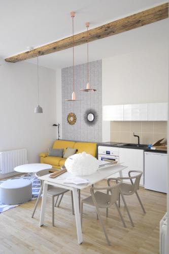 cocina y comedor con mesa blanca y sillas en Cosy apartment ideally located in the Old Town, en Lyon