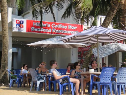 a group of people sitting at a table under umbrellas at Paradise Bay in Beruwala