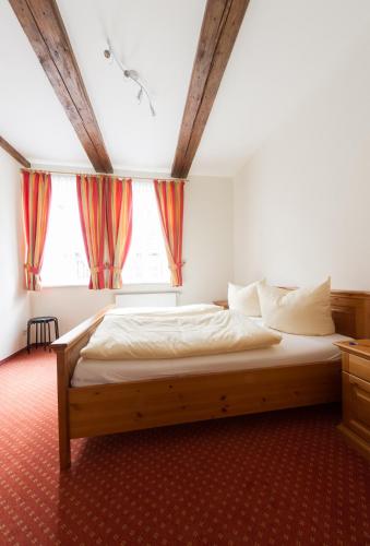 a bedroom with a large bed in front of a window at Ferienwohnungen am Klint in Wernigerode