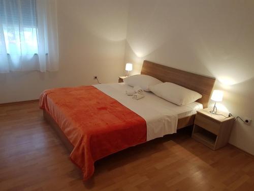 1 dormitorio con 1 cama grande con manta roja en Apartment Viki, en Zadar