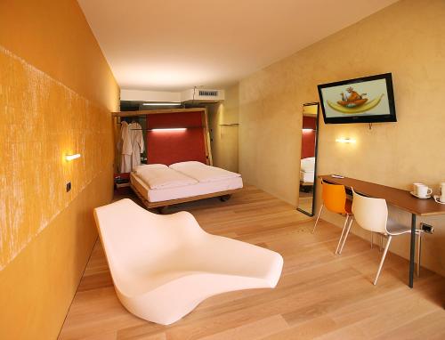 a small room with a bed and a table and chairs at Ambienthotel PrimaLuna 3S in Malcesine