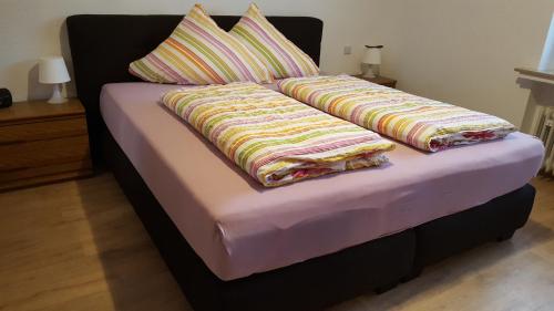 a bed with two blankets on top of it at Ferienwohnung Debray in Winterberg
