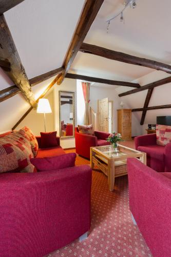 a living room with purple couches and a table at Ferienwohnungen am Klint in Wernigerode
