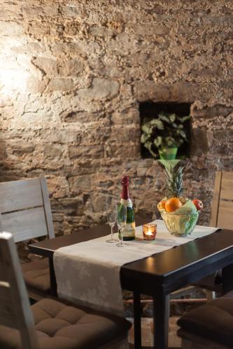 a table with a bottle of wine and a bowl of fruit at Ferienwohnungen am Klint in Wernigerode