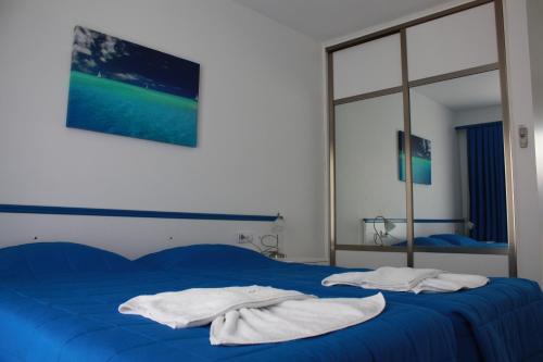 a bedroom with a blue bed with towels on it at Rota Hotel in Dalyan