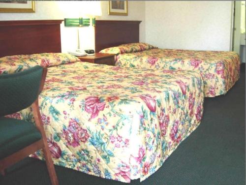 um quarto de hotel com duas camas e uma cadeira em America's Best Inn & Suites - Decatur em Decatur