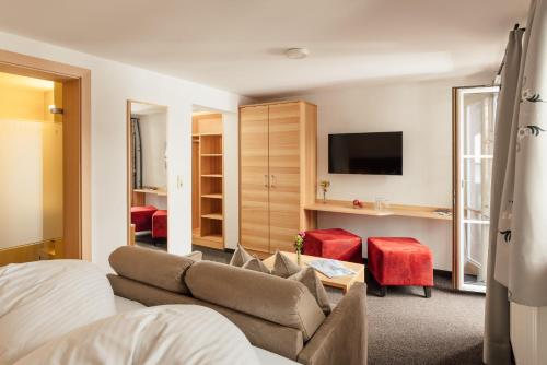 ein Wohnzimmer mit einem Sofa und einem TV in der Unterkunft Landhaus Albert Murr - Bed & Breakfast in Sankt Anton am Arlberg