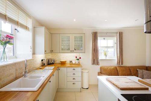 a kitchen with a sink and a couch at 1 Collared Dove Barn in Stoke on Trent