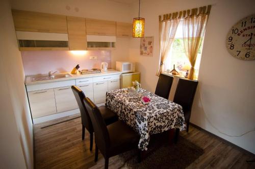 eine Küche mit einem Tisch und Stühlen sowie eine Küche mit einem Waschbecken in der Unterkunft Green Garden in Šip