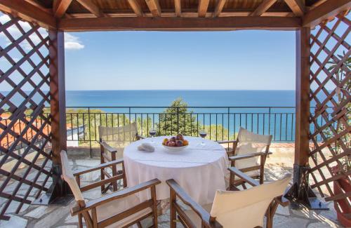 a table in a gazebo with a view of the ocean at Pantheon in Agios Ioannis Pelio