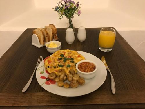 een ontbijtplateau met een omelet en een bord met eten bij Park Farmhouse Bed and Breakfast in Washaway