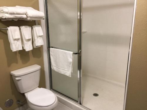 a bathroom with a toilet and a shower with towels at Comfort Suites Uniontown in Uniontown