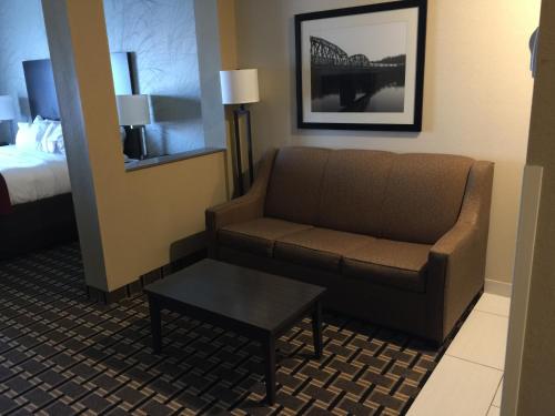 a hotel room with a couch and a bed at Comfort Suites Uniontown in Uniontown