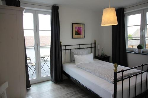a bedroom with a bed and a balcony at Pension Willebuhr in Mayen