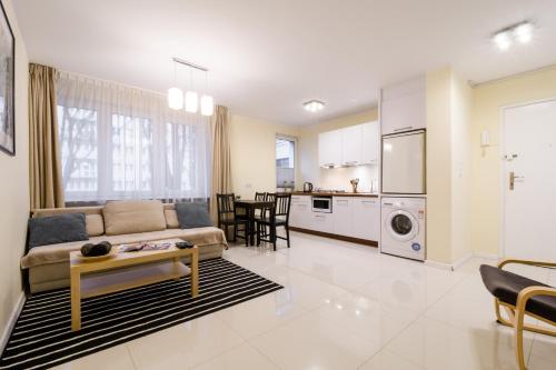 a living room and kitchen with a couch and a table at Budgetplus Key Apartaments Pańska in Warsaw