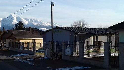 a house with a fence and a mountain in the background at Apartmán Pod Klinom in Pribylina