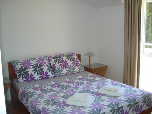 a bedroom with a purple and white bed with towels on it at Apartment Luna in Dubrovnik