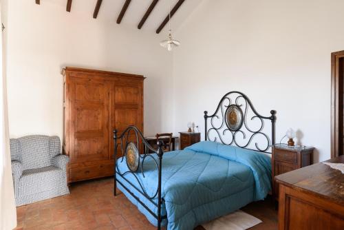 ein Schlafzimmer mit einem Bett und einem Stuhl darin in der Unterkunft Agriturismo Barbi in Monticchiello