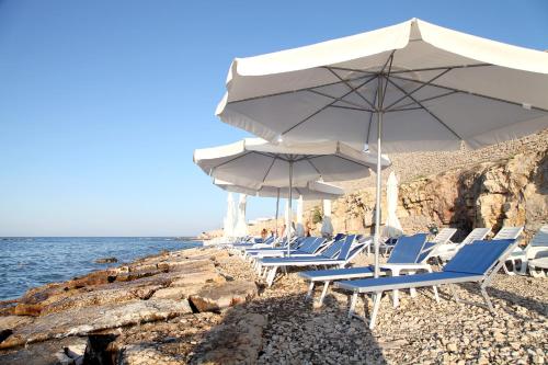 a group of chairs and umbrellas on a beach at Nicotel Bisceglie in Bisceglie