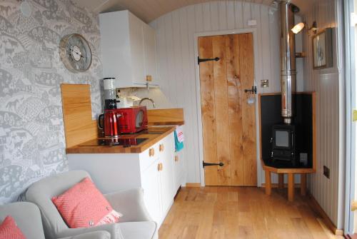 a small kitchen with a red appliance on a counter at The Little John Petite Cosy Log Cabin - Sleeps 2, great for romantic breaks, couples, single guests, near Sherwood Forest at Fairview Farm, Nottingham set in 88 acres in Blidworth