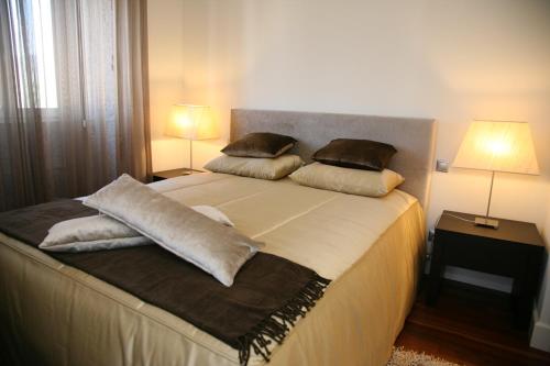 a bedroom with a large bed with pillows on it at Casa D' Joao Enes - Afife Residence in Afife