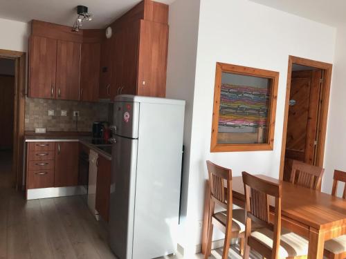 a kitchen with a refrigerator and a table with chairs at Font Romeu Via (Maison du Soleil) in Font-Romeu-Odeillo-Via