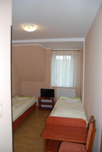 a small room with two beds and a television at Wisełka PERŁA Bałtyku in Wisełka