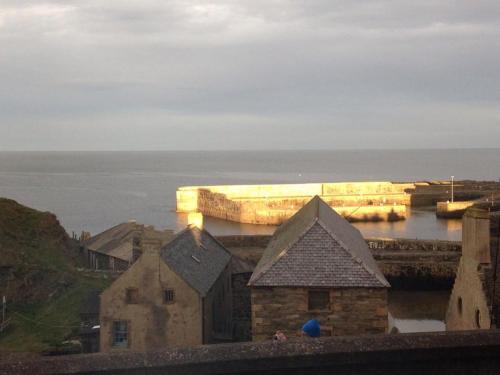 a view of a pier with a boat in the water at Station Hotel Portsoy in Portsoy