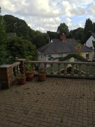 a fence and potted plants in front of a house at Wynberg House Bed & Breakfast Swansea in Swansea