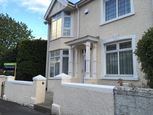 a house with a white fence in front of it at Wynberg House Bed & Breakfast Swansea in Swansea