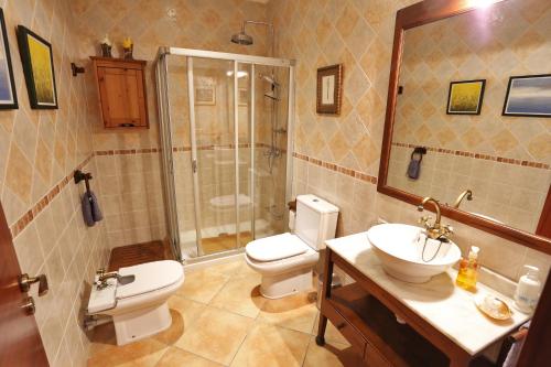 a bathroom with a toilet and a sink and a shower at Flowers House in Maria de la Salut
