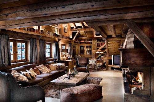 a living room with a couch and a fireplace at Chalet des Fermes de Marie, avec services, Collection Chalets des Fermes in Megève