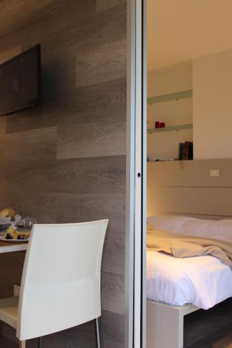 a bedroom with a bed and a white chair at Ca degli Artisti in Trevignano