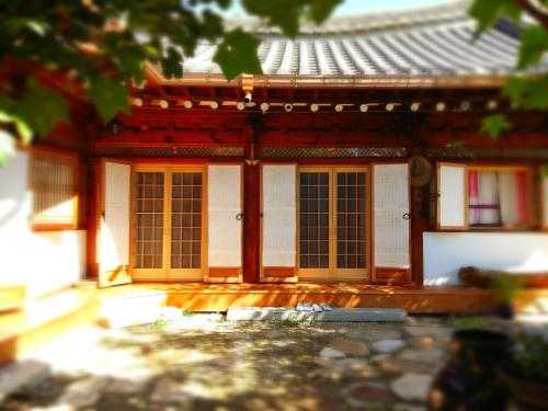 Zugang zu einem Gebäude mit orangefarbenen Türen in der Unterkunft Dalbbit hyang in Jeonju