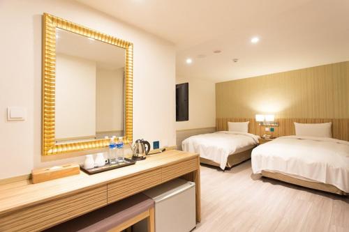 a hotel room with two beds and a mirror at Rainbow Hotel in Taipei