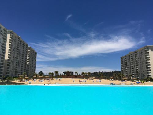 a view of a beach with buildings and people at Departamento en Laguna Bahia in Algarrobo