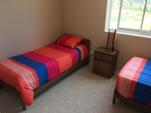 a bedroom with a bed and a night stand and a window at Departamento en Laguna Bahia in Algarrobo