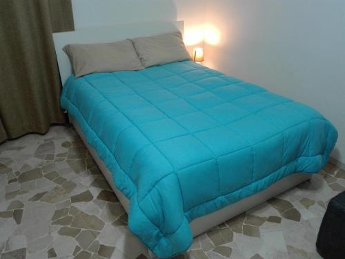 ミラノにあるMetropolitan Apartmentの青い掛け布団付きのベッド1台