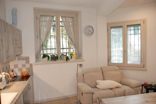 a living room with a couch and two windows at Casa Anita in Limone sul Garda