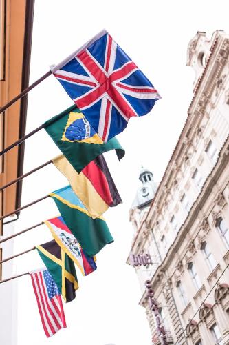 a group of flags flying in front of a building at Hotel Rous in Plzeň
