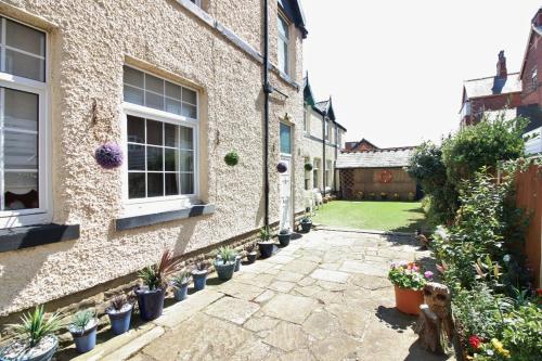 a courtyard of a house with potted plants at The Coach House Apartment in Lytham St Annes